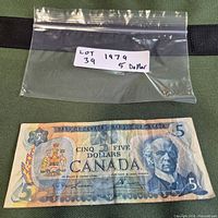 Full view of 1979 $5 Canadian banknote with plastic bag above