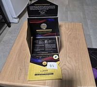 Tri-fold box open showing coin capsule and COA flap