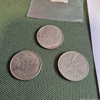 Three Canadian quarters on green fabric