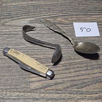 Overall view of two spoons and pocket knife on tabletop