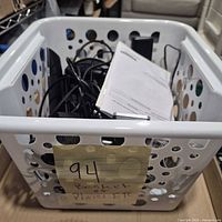 Overall view of basket showing assorted phones, bases, cables and manuals
