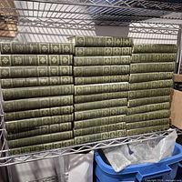 Full view of all green Centennial Edition volumes stacked on wire shelf
