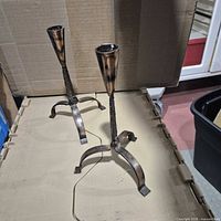 Pair of coppertone wrought iron candlesticks on tabletop