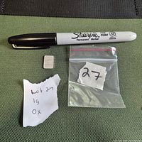 Silver bar beside marker for scale and plastic bag