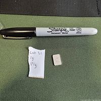 Scale comparison with marker and paper label; shows front of silver bar