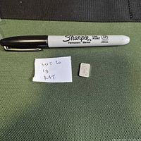 Full view of pen for scale, note with lot number, and the 1-gram silver bar