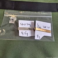 Two Timken tie clips in bag with weight notes