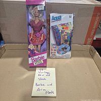 Front view of sealed Barbie Style doll and sealed Aqua arm floats
