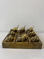 Front view of brass tic tac toe board with all playing pieces in place