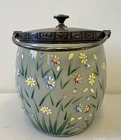Front view of green opaline biscuit barrel with enamel flowers, lid and handle