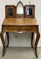 Front view of desk showing upper cabinets, mirror, slant front and legs