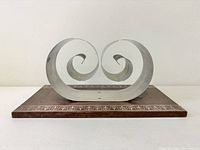 Front view showing chrome double scroll arms on wood base