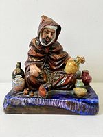 Front view of Royal Doulton "The Potter" figurine showing seated man with pots