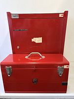 Closed red tool chest positioned against cabinet back showing Beach Industries badge and latches