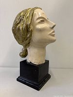 Left front view of fibreglass female bust on black wood base