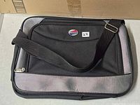 Front view of American Tourister laptop bag showing strap and trim