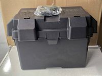 Overall view of black Group 27 battery box with strap on lid
