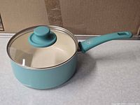 Side view of turquoise GreenLife saucepan with lid attached