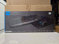 Front of sealed retail box showing keyboard, mouse and pad