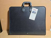 Front of black portfolio case showing handle and tag