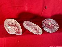 Top view of three cut crystal pieces on red cloth