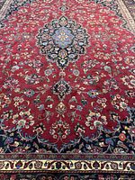 Full view of central area showing red field, navy medallion, floral pattern