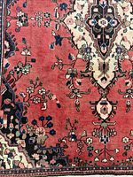 Corner of rug showing red ground, floral motifs and part of medallion