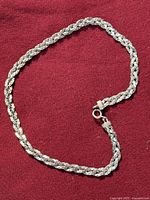 Necklace laid in open loop showing braided pattern and clasp