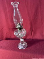 Full assembled oil lamp against red backdrop