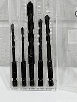 Front view of five of the six black oxide hex-shank drill bits in plastic case