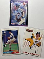 Front views of three Greg Maddux baseball cards