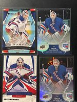 Four Henrik Lundqvist cards laid out on black surface
