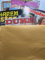 Stack of seven adult magazines partially visible