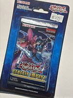 Front of sealed blister showing Genesis Impact artwork and English 1st edition labeling