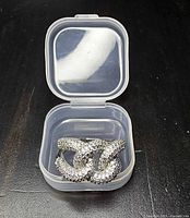 Top view of rhinestone interlocking loop ring in clear plastic box