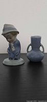 Front view of Wade Poor Man figurine and blue vase
