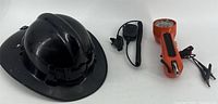 Black fire safety helmet, orange butt-set phone, black shoulder mic laid out