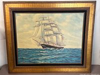 Front view of framed oil painting showing ship scene