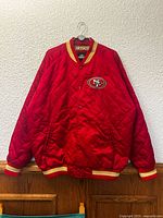 Front view of red quilted bomber jacket with chest logo visible