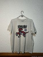 Front view of T-shirt showing Raptors dinosaur graphic and overall wear