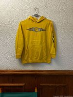 Front view of yellow Nike flame graphic hoodie hanging