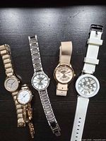 Five Anne Klein watches laid out showing dials and straps