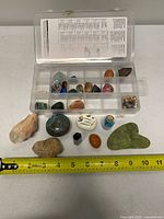 Overall view of organizer box and loose stones displayed with ruler for scale