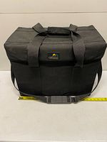 Front view of Cameron padded equipment bag showing logo, handles, shoulder strap, and measuring tape for width