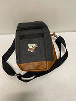 Front view of grey felt cooler bag with tan faux-leather base and Langara Fishing Adventures logo