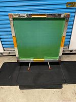 Table folded upright showing green playing surface and perimeter edging