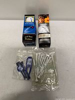 Front view of two boxed golf balls and two sealed tee packs