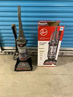 Full view of Hoover upright vacuum next to original box