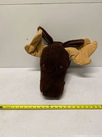 Front view of plush moose head with measuring tape