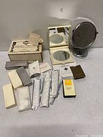 Lot overview showing boxed lithophane night light, two vanity mirrors and grouped amenity kits